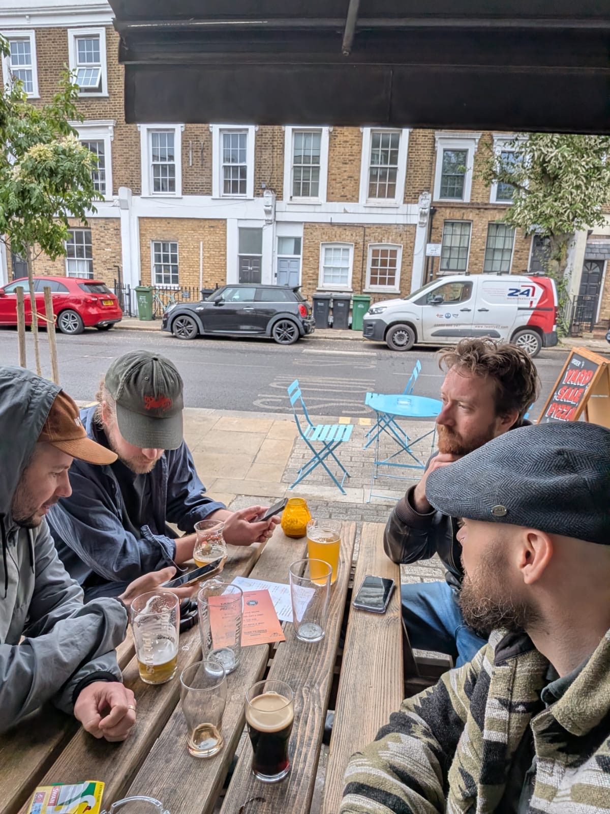 Four band members around a pub table